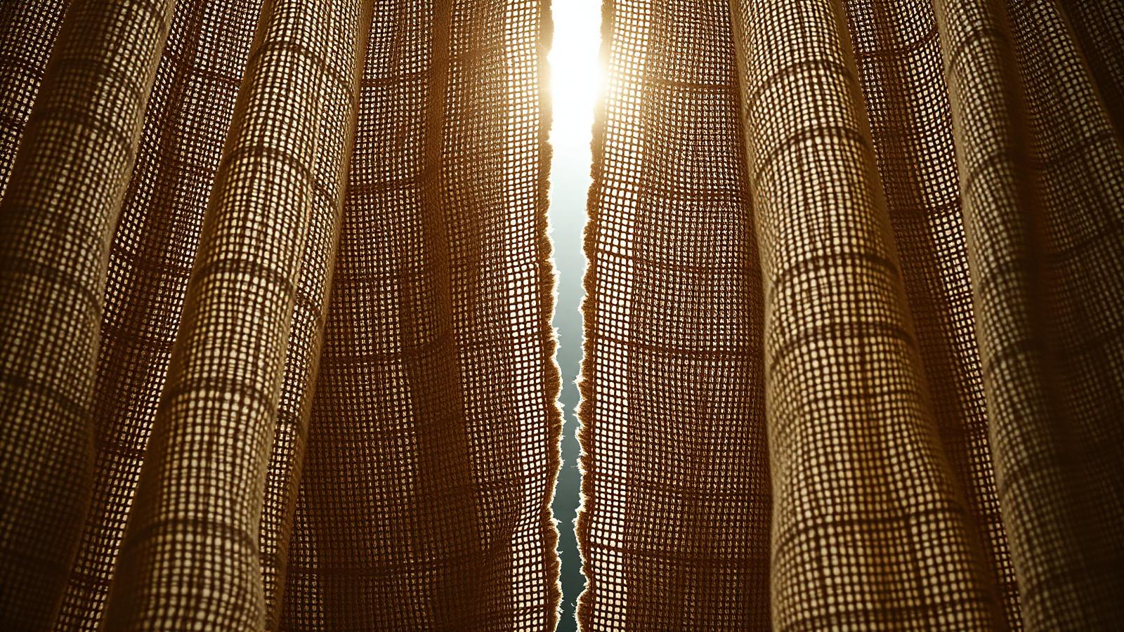 A heavy woven veil torn down the middle with intense light bursting through the tear